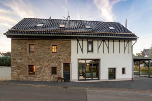 una casa in mattoni con tetto nero di Glamorous Cottage Chimney Sauna a Dahlem