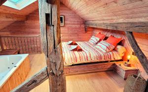 a bedroom in a wooden cabin with a bed and a tub at Les Monts d'Aisne in Mormont