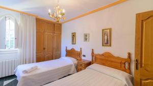 sypialnia z 2 łóżkami i żyrandolem w obiekcie Villa Rural Paquete Pozo Alcón by Ruralidays w mieście Pozo Alcón +25 zdjęć