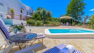 a patio with a table and chairs next to a swimming pool at Casa de Juanito Viñuela by Ruralidays in Viñuela