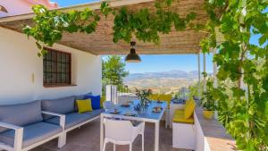 a patio with a table and chairs and a view at Casa de Juanito Viñuela by Ruralidays in Viñuela