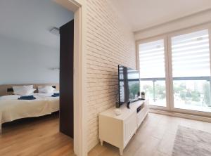 a bedroom with a bed and a white brick wall at Sołtysa Dytmara 3 by Homeprime in Krakow