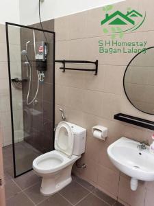 uma casa de banho com um WC, um chuveiro e um lavatório. em S H Homestay Bagan Lalang em Sungai Pelik