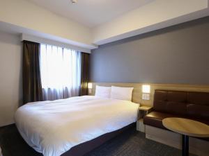 Ένα ή περισσότερα κρεβάτια σε δωμάτιο στο Dormy Inn Hiroshima Annex