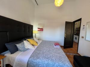 a bedroom with a large bed with a black headboard at Ground floor apartment very close to the sea! in Alcalá