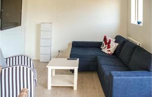 ein Wohnzimmer mit einem blauen Sofa und einem Tisch in der Unterkunft Berg En Zee 4 in Bergen aan Zee + 6 Fotos