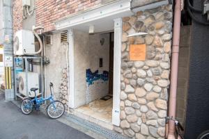 ein Fahrrad, das vor einem Gebäude mit einer Steinmauer geparkt ist in der Unterkunft MELL-THEATHER - Vacation STAY 10360 in Osaka