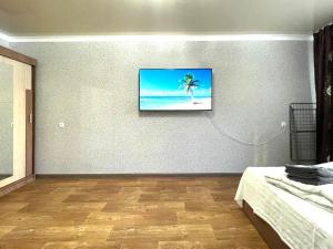 ein Wohnzimmer mit einem TV an der Wand in der Unterkunft Абая 68 квартира в центре, 4 спальных места in Petropawlowsk