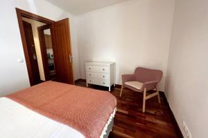 - une chambre avec un lit, une chaise et une commode dans l'établissement Prime Location - Historic District with Private Parking, à Lisbonne