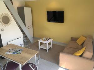 a living room with a couch and a table at Studio à la campagne in Montcornet