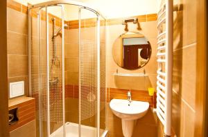 a bathroom with a glass shower and a sink at Sanatorium Energetyk in Krynica Zdrój