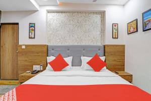 a bedroom with a large bed with red pillows at OYO Hotel R S Palace in Ahmedabad