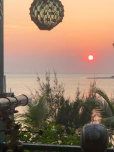 einen Sonnenuntergang über dem Strand mit dem Ozean im Hintergrund in der Unterkunft Muchilena fishing club & suites 