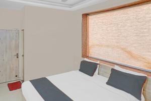 ein Schlafzimmer mit einem weißen Bett und einem Fenster in der Unterkunft Super Collection O Hotel Sundew in Jaipur