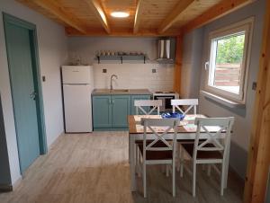 a kitchen with a table and chairs and a refrigerator at Xristos apartment and maisonettes in Sykia Chalkidikis