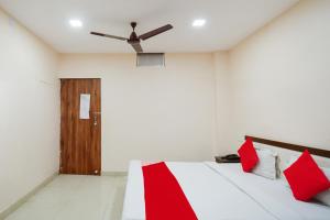 a bedroom with a bed with red pillows and a ceiling fan at Flagship 85554 Hotel Premium Hari in Jamshedpur