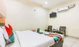 Cette chambre comprend un lit et une télévision. dans l'établissement FabExpress Mayank Palace, à Chandigarh