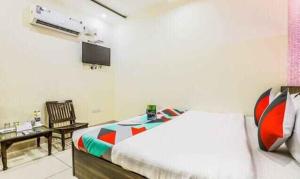 - une chambre avec un lit, une chaise et une télévision dans l'établissement FabExpress Mayank Palace, à Chandigarh