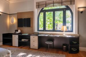 a bedroom with a desk and a large window at Casa da Marechal - Boutique Hotel by Oporto Collection - Adults Only in Porto