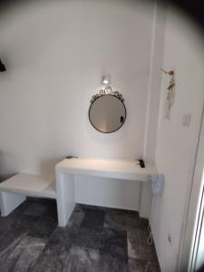 a white bathroom with a sink and a mirror at Marisini Sea View in Batsi