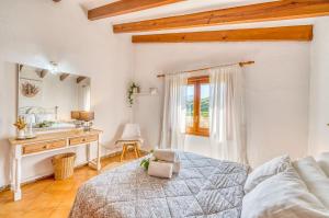 a white bedroom with a bed and a desk at Ideal Property Mallorca - Can Carabassot in Pollença