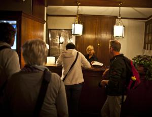 a group of people standing around a counter in a bar at Auberge du Raisin in Cully