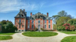 una gran casa de ladrillo rojo con un gran patio en Château de Chantore en Bacilly