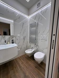 a white bathroom with a sink and a toilet at Cuore D'aMare B&B in Bari