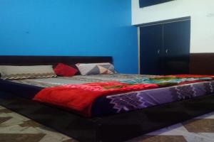 a bed with a colorful blanket on it in a room at OYO Hotel Rosewood in Palwal