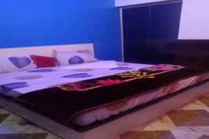 a large bed in a room with a blue wall at OYO Hotel Rosewood in Palwal