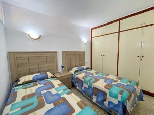 a bedroom with two beds and two closets at Edificio Playa in Los Cristianos