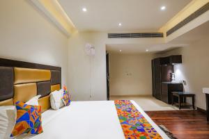 a bedroom with a large bed and a bathroom at FabHotel Grand Stay in New Delhi