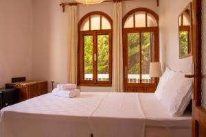 1 dormitorio con 1 cama blanca grande y 2 ventanas en Deta, en Ildir