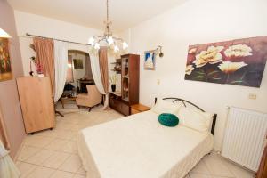 a bedroom with a white bed and a desk at Villa Makrades Deluxe in Makrádes