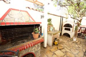 a room with a brick fireplace and a pizza oven at Villa Makrades Deluxe in Makrádes