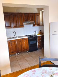 cocina con armarios de madera y estufa negra en Apartment Danica 356, en Umag