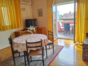 un soggiorno con tavolo e vaso di fiori di Apartment Danica 356 a Umag (Umago)