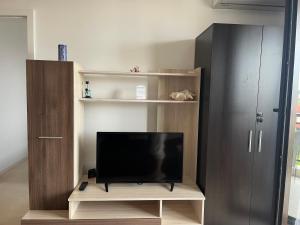 a flat screen tv sitting on a wooden entertainment center at Green Life Beach Resort Paradise Apartment in Sozopol