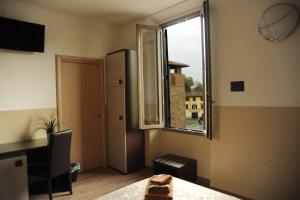 a room with a window and a desk and a table at Guesthouse Buonarroti Florence in Florence