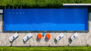 an overhead view of a swimming pool with lounge chairs andarios at ibis Styles Bangkok Silom in Bangkok