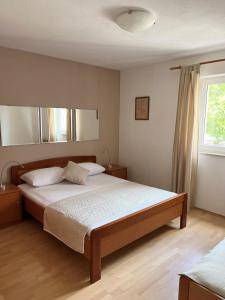 Un dormitorio con una cama grande y una ventana en Apartment Araucaria, en Crikvenica