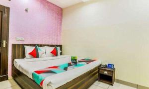 a bedroom with a bed and a pink wall at FabExpress Mayank Palace in Chandīgarh
