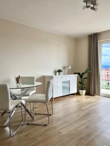 een eetkamer met een tafel en stoelen en een raam bij Apartment Araucaria in Crikvenica
