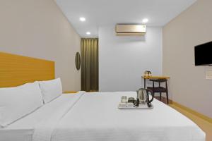 1 dormitorio con 1 cama blanca grande y plateada en Super Townhouse 862 Che Sigma, en Hyderabad