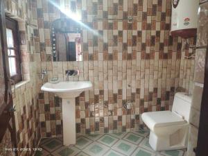 y baño con lavabo y aseo. en OYO Home Homestay Sabzar Ahmad Gorsi, en Pahalgām