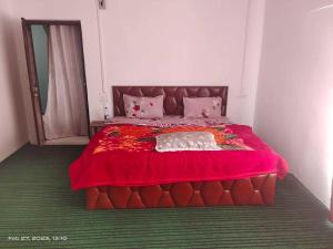 1 dormitorio con cama roja y manta roja en OYO Home Homestay Sabzar Ahmad Gorsi, en Pahalgām