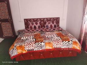 una cama con un edredón colorido y almohadas en ella en OYO Home Homestay Sabzar Ahmad Gorsi, en Pahalgām