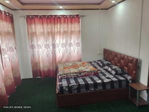 1 dormitorio con 1 cama en una habitación con cortinas rojas en OYO Home Homestay Sabzar Ahmad Gorsi, en Pahalgām