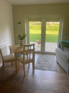 ein Wohnzimmer mit einem Tisch und einem Hund mit Blick auf die Tür in der Unterkunft Cherry Farmhouse in York