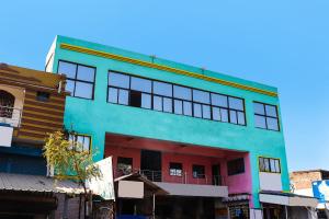 a brightly colored building with windows on a street at OYO 86877 Hotel Bhuneshwar Inn in Rāmgarh